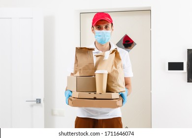 Courier In Protective Mask And Medical Gloves Delivers Takeaway Food. Delivery Service Under Quarantine, Disease Outbreak, Coronavirus Covid-19 Pandemic Conditions.