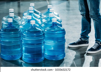 Courier standing by large bottles with drinking water