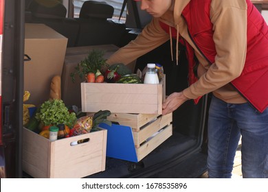 Courier Taking Crate With Products From Car, Closeup. Food Delivery Service