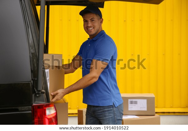 Courier taking\
parcel from delivery van\
outdoors