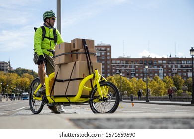courier traveling with his cargo bike through the city, lateral view