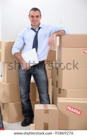 Courrier stood by stacked boxes