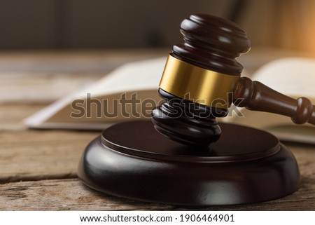 Court and justice. Judge's hammer on a wooden table against the background of books, constitution