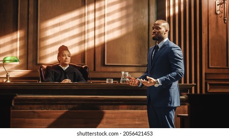 Court Of Justice And Law Trial: Male Public Defender Presenting Case, Making Passionate Speech To Judge, Jury. African American Attorney Lawyer Protecting Client's Innocents With Supporting Argument.