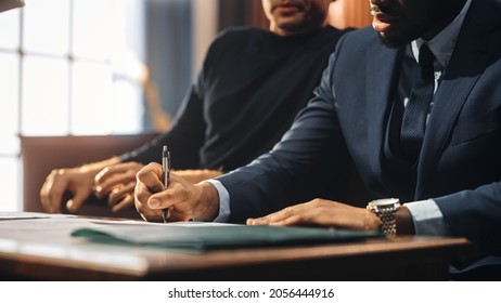 Court of Justice and Law Trial: Male Barrister Writes Down Arguments for Defence Strategy. African American Attorney Lawyer Fight for Freedom of His Client with Supporting Evidence. Close Up.