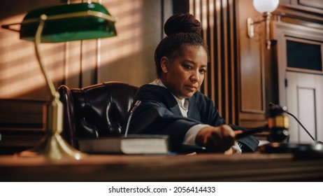 Court Of Law Trial In Session: Portrait Of Honorable Female Judge Reading Decision, Striking Gavel. Presiding Justice Pronouncing Judgment Sentence. Innocent Or Guilty Verdict. Cinematic, Dramatic