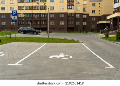 the courtyard of a large multi-storey residential complex in the summer with parking spaces for cars. Parking spaces for drivers with disabilities.