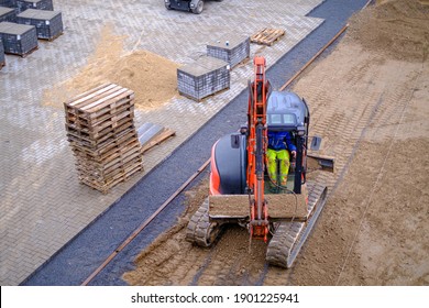 A Courtyard Is Paved With Paving Stones By A Civil Engineering Company With The Help Of An Excavator