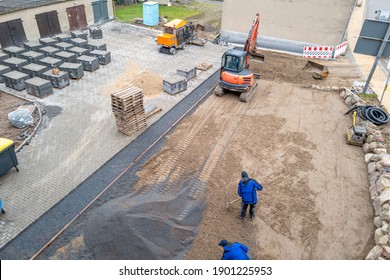 A Courtyard Is Paved With Paving Stones By A Civil Engineering Company With The Help Of An Excavator