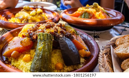Couscous  is a Maghrebi dish of small (about 3mm diameter) steamed balls of crushed durum wheat semolina, usually served with a stew spooned,vegetables at family gatherings.