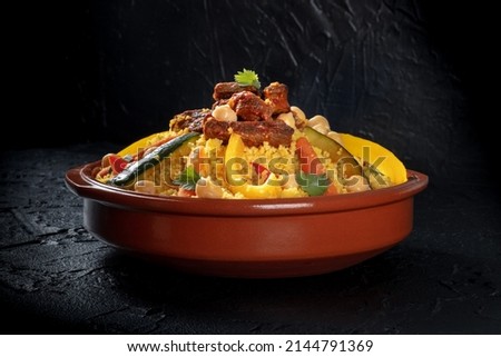 Couscous with meat and vegetables, traditional Moroccan dish, with chickpeas and cilantro, on a black background