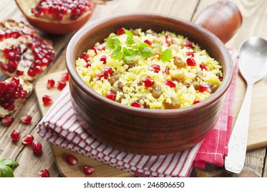Couscous with pomegranate, raisins and spices on the table