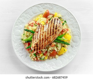 Couscous Salad With Grilled Chicken And Asparagus On White Plate. Wooden Table. Healthy Food