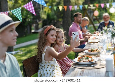 Cousins taking a selfie at a family garden party. Family reunion at garden barbecue party. - Powered by Shutterstock