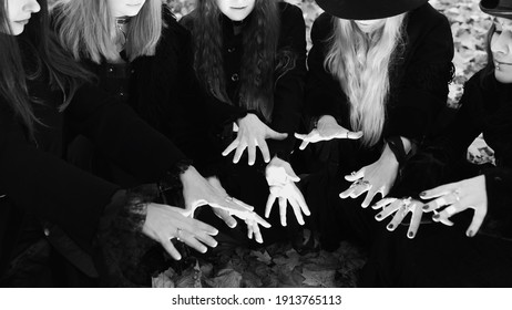 Coven Of Witches, Modern Witches Gathered And Do A Ritual In The Park. Halloween, A Group Of Different Women Like Witches In Black And Hats.