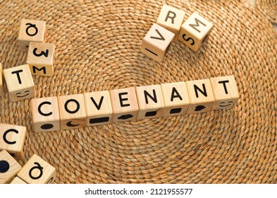 COVENANT Word Text From Wooden Cube Block Letters On Braided Rattan Mats Background. Covenant Is A Formal Written Agreement Between Two Or More People Or Groups Of People Which Is Recognized In Law.