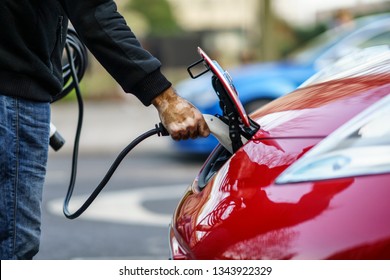 Coventry, UK - February 23, 2019: Owner Of Nissan Leaf Electric Car Plugged The Charger Of The Car In City Centre Of Coventry