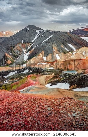 Cover page with colorful Icelandic rainbow volcanic Landmannalaugar mountains at famous Laugavegur hiking trail in Iceland, dramatic summer scenery, with rainy sky