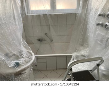 Covered Bathroom Walls With Tarp And Ladder In Preparation For Painting - House Renovation Concept