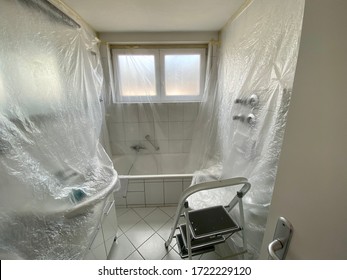 Covered Bathroom Walls With Tarp And Ladder In Preparation For Painting - House Renovation Concept