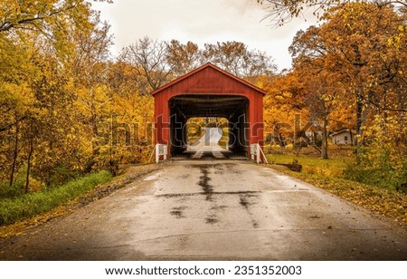 Covered bridge in the autumn forest. Red covered bridge in autumn. Autumn covered bridge. Covered bridge in autumn forest