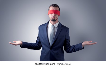 Covered eye, indecisive businessman standing blind in front of a wall