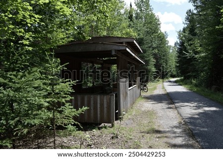 covered rest stop with a old train wagon theme, along the Le P-tit train du Nord bicycle tail near La Macaza , Quebec Canada