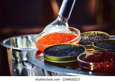 Covered and served furshet table, outdoor. Red and black caviar and vodka