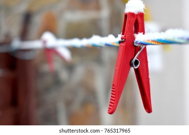 Covered with snow red clothespin on the colorful line, close-up - Shutterstock ID 765317965