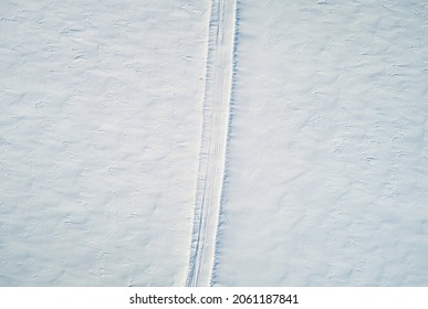 Covered with snow road path in winter field background above top drone view