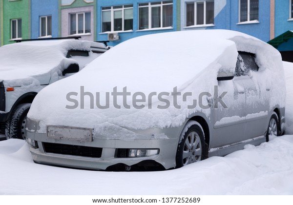 Сar\
covered with snow stands in the parking lot of residential building\
in winter. Сoncept of bad weather, snowfall, harsh weather\
conditions, frost, blizzard, car engine did not\
start