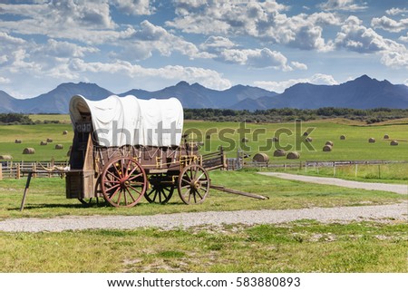 covered wagon against a mountain landscape