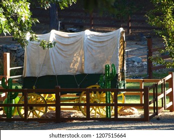 Covered Wagon In An Apple Hill Farm, Inside A Fence, Shaded By Trees, Placerville, California USA