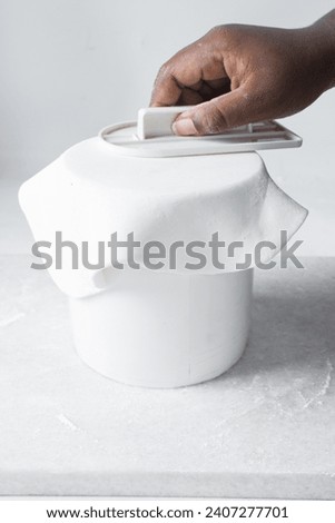 Covering a cake with fondant, paneling a Styrofoam cake dummy with fondant icing