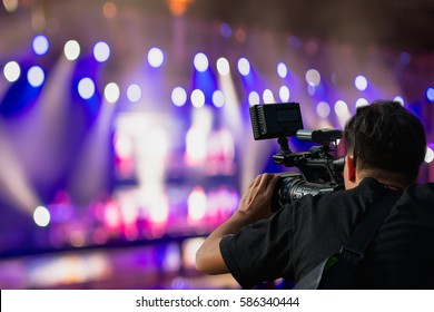 Covering an event on stage with a video camera.