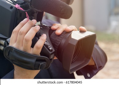 Covering an event with a video camera., Videographer takes video camera with free copy space for text., Video camera operator working with his equipment., close up of television operator with camera.