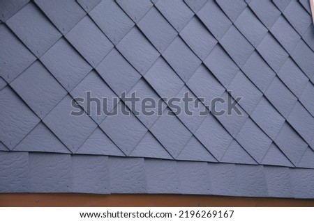 covering the wall of the house from square tiles hammered onto a wooden grid. the ventilated wall protects against moisture and frost in mountain conditions. ridges of mountains