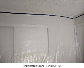 Covering Wall With Tarp In Preparation For Painting