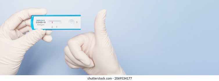 Covid 19 Antigen Nasal Rapid Test Kits For Self-testing. Top View Hands With Medical Gloves Show A SARS-CoV-2 Testing Result Which Is Negative And Do Thumbs Up. New Normal, Safety, Protect, Recommend.