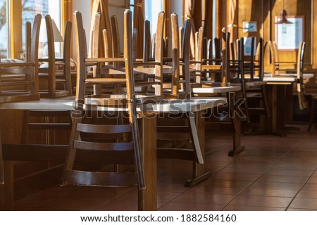 Covid 19 and closed restaurant with chairs on tables because of lockdown or shutdown. horizontal