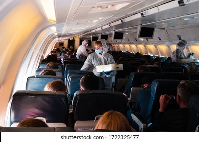 Covid 19 Coronaviruse Travel Protection. Aircraft Crew In Protective Suits And Masks During A Pandemic Corona Virus. Passengers Fly To America, Repatriation Of American Citizens To USA With Plane.