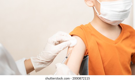 COVID 19 Vaccination for Kids concept. Close up hands of a nurse  giving a little boy first dose of Covid Vaccine in hospital. Authorized, Approved, Trial, Safe, Available, Back to school, Asian, Asia - Shutterstock ID 2000872115