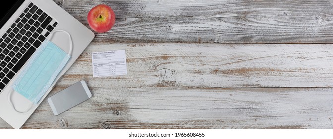 Covid 19 Vaccination Record Card For Going Back To School Or Work On White Wooden Desktop Setting.  Individual Record For Use During The Covid 19 Coronavirus Global Pandemic 