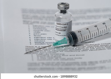 Covid 19 Vaccine Side Efects. Covid Vaccine Vial An Syringe And The Side Effect Paper.