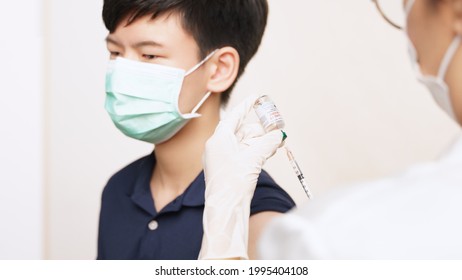 COVID 19 Vaccines For Kids And Teenager Issue. A Smart Asian Teen Boy With Medical Face Mask About To Get A Vaccine Shot At The Hospital. Safe, Authorized, Back To School, Insurance, Healthcare.