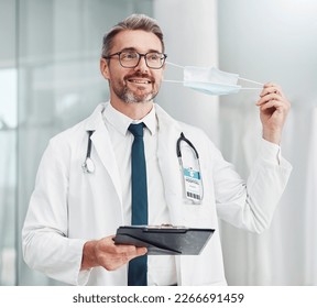 Covid, finished and doctor remove mask as corona end and ease on restrictions in a hospital or clinic with happy medical worker. Smile, done and healthcare professional leaving health centre - Powered by Shutterstock