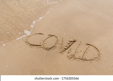 Covid free, stop Covid, safe beach and holiday, word written on the sand, vaccine