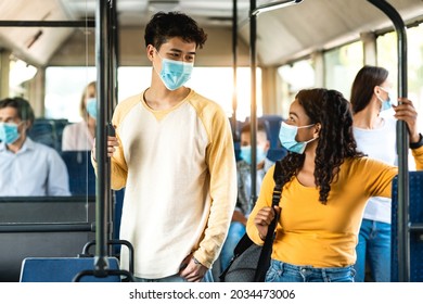 Covid Healthcare, Lifestyle And People Concept. Smiling Diverse International People Wearing Protective Medical Masks Talking, Asian Guy And African American Lady Standing In Autobus Holding Handle