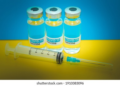 Covid Injection Vaccine Vials For Coronavirus With Syringe On Blue And Yellow Background. Vaccine Covid-19 SaRS Ampoules On Ukraine Flag Colors. Close Up, Vignetted