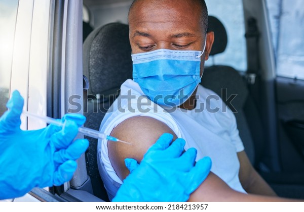 Covid, medical worker and vaccine site and service for\
patient getting flu shot or dose for coronavirus prevention. Man in\
car wearing protective face mask to avoid contact while getting\
an